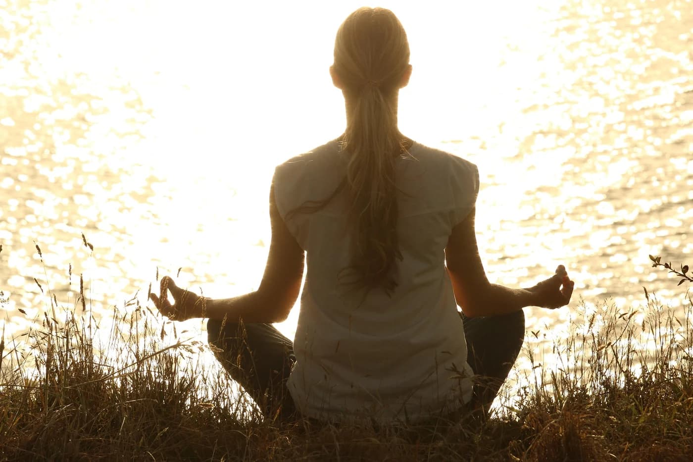 Méditation taoïste — femme en posture de lotus au coucher du soleil